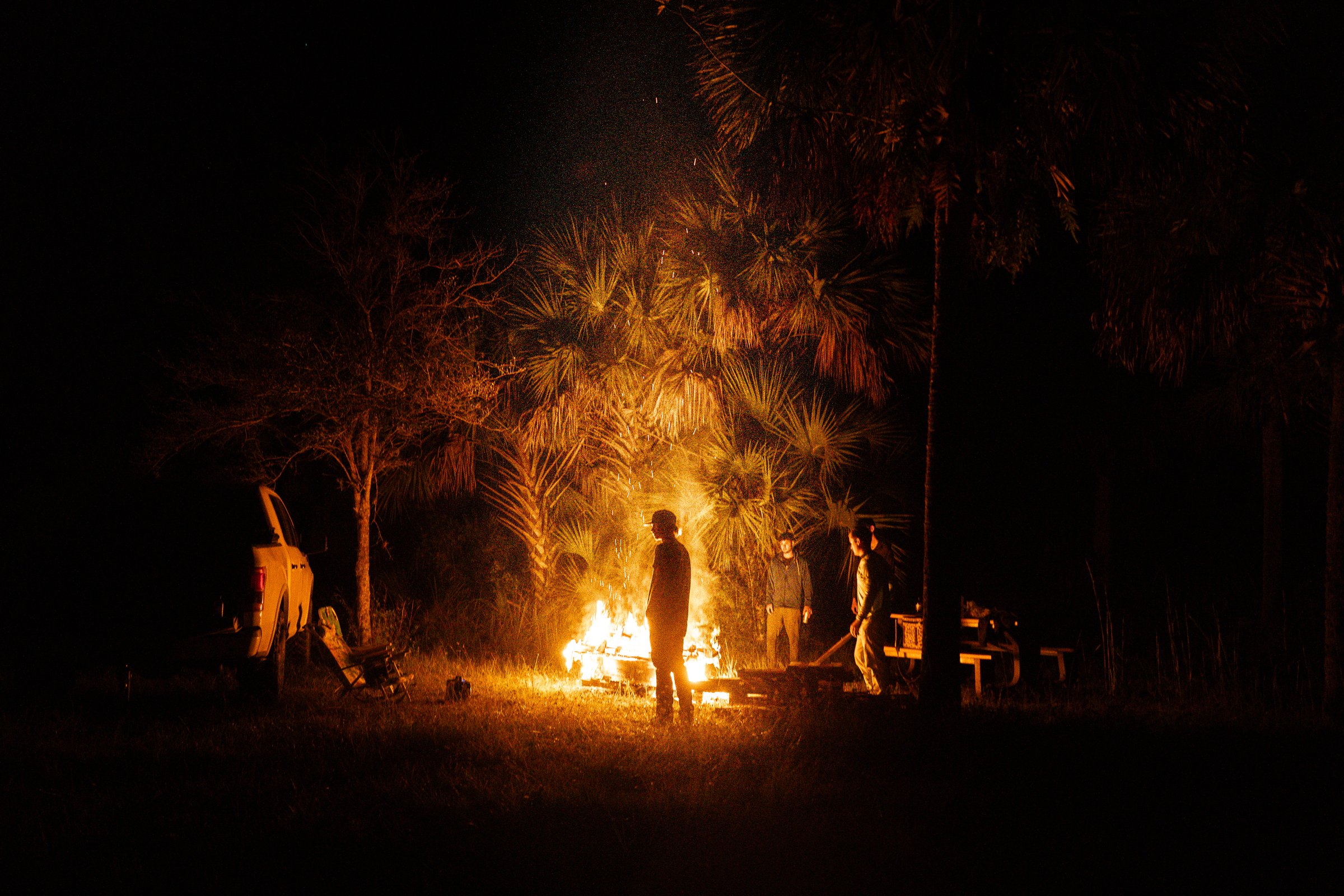 Bonfire gathering at night, fire as subject and element